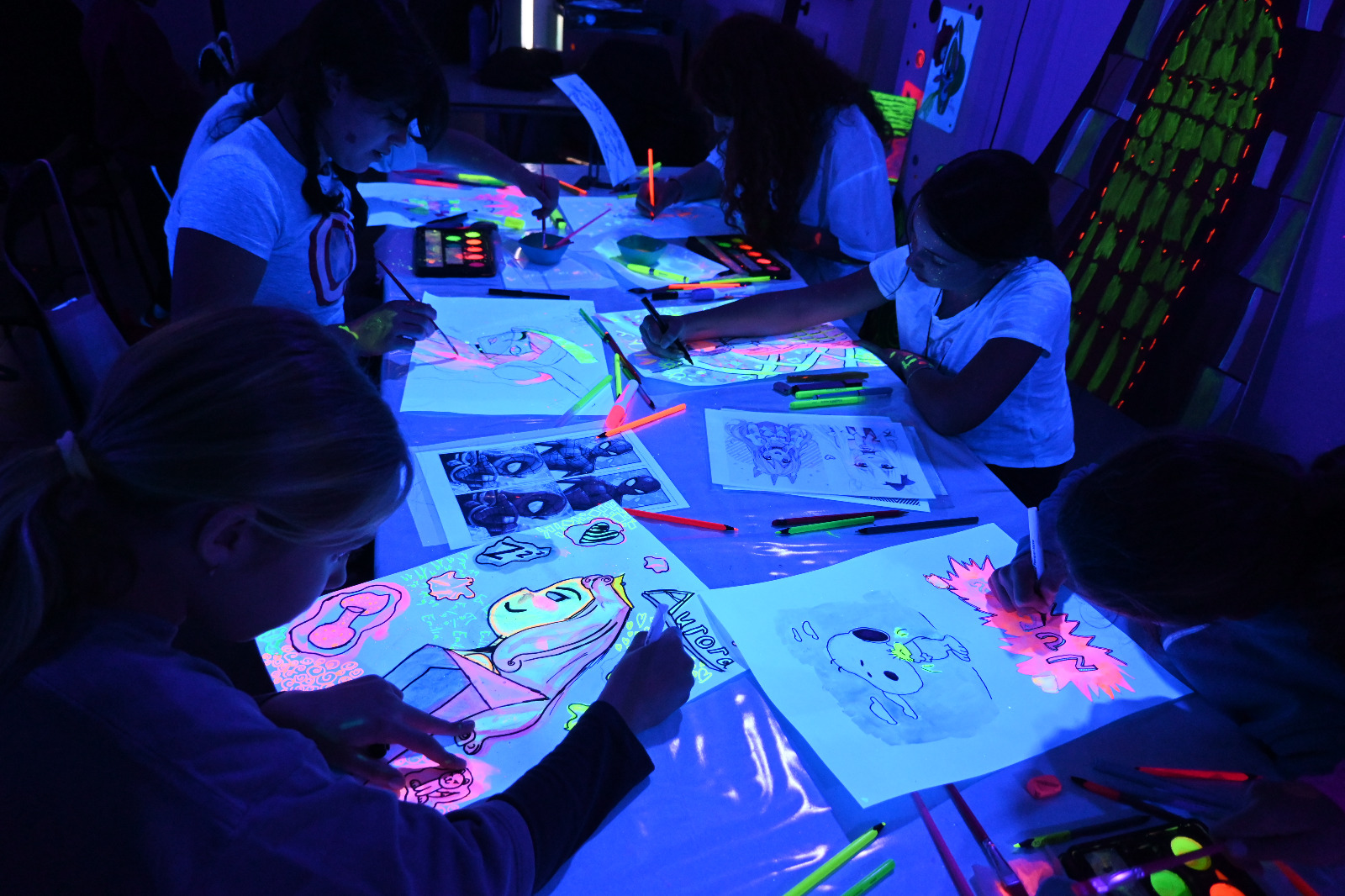 Niñas y niños creando con pintura neón en el Taller de Arte Rivas